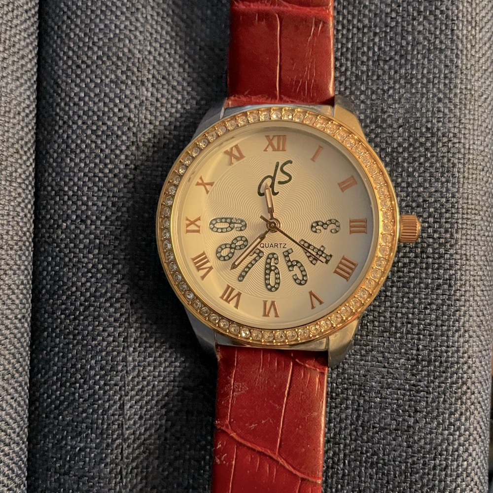 DS gold round faced watch with rhinestone edging.